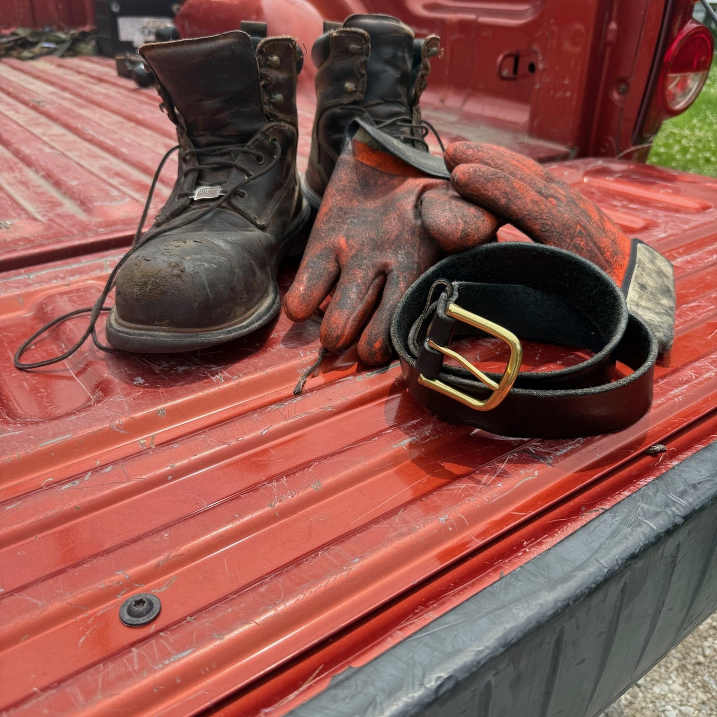workhorse on the tailgate with boots and gloves, gold hardware